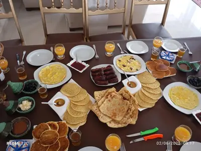 a table with breakfast foods and drinks on it at Lina Village in Al Hachlaf