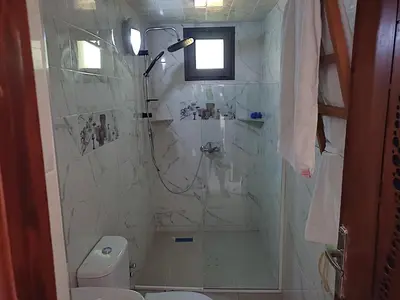 a bathroom with a shower and a toilet at Lina Village in Al Hachlaf
