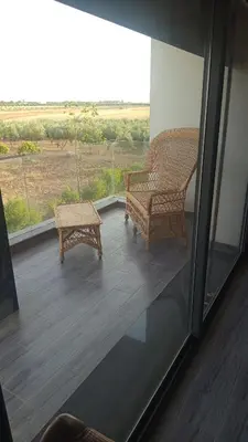 a balcony with a chair and a bench on it at Lina Village in Al Hachlaf
