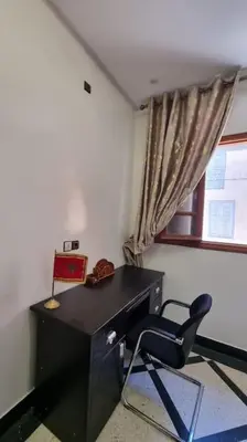 a desk and a chair in a room with a window at Spacieux Appartement in Azrou