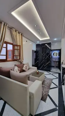 a living room with a couch and chairs and a table at Spacieux Appartement in Azrou