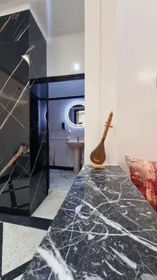 a bathroom with a black counter top and a toilet at Spacieux Appartement in Azrou