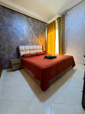 a bedroom with a bed with a red bedspread at Home louah in Fès