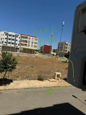 a view of a field with buildings in the background at Home louah in Fès