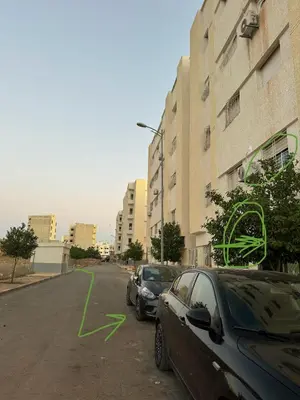 two cars parked in a parking lot next to a building at Home louah in Fès