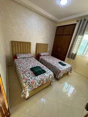 two beds sitting in a room with at Home louah in Fès