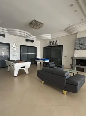 a living room with a couch and a ping pong table at Super belle villa avec piscine in Fès