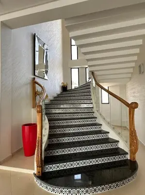 a staircase with black and white steps in a house at Super belle villa avec piscine in Fès
