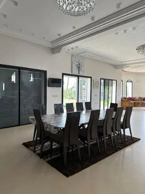 a large dining room with a table and chairs at Super belle villa avec piscine in Fès
