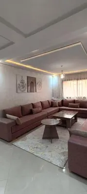 a living room with a brown couch and tables at APPART-HOTEL La MAISON ATTAWBA 1 in Beni Mellal