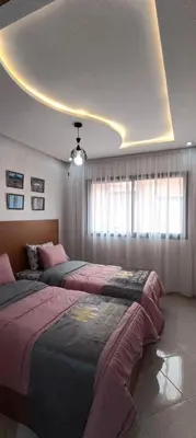 a bedroom with two beds and a ceiling at APPART-HOTEL La MAISON ATTAWBA 1 in Beni Mellal