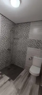 a bathroom with a white toilet and a shower at APPART-HOTEL La MAISON ATTAWBA 1 in Beni Mellal