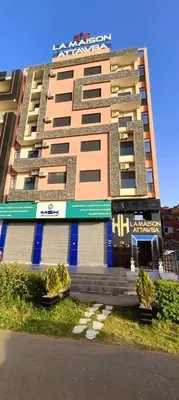 a tall apartment building withcriptions on the side of it at APPART-HOTEL La MAISON ATTAWBA 1 in Beni Mellal