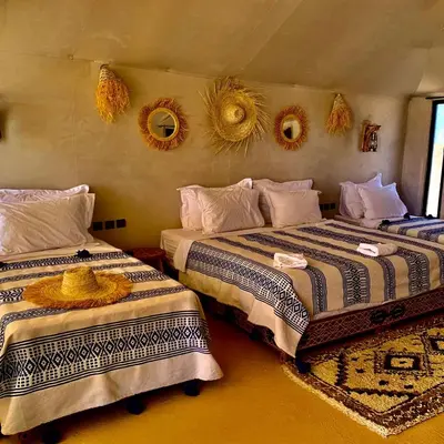 two beds in a room with mirrors on the wall at Aurum Dunes Luxury Camp in Merzouga