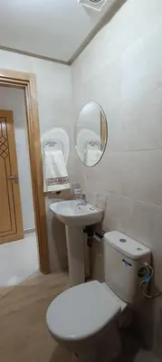 a bathroom with a toilet and a sink and a mirror at APPART-HOTEL La MAISON ATTAWBA 2 in Beni Mellal