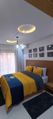 a bedroom with a bed with a blue and yellow blanket at APPART-HOTEL La MAISON ATTAWBA 2 in Beni Mellal