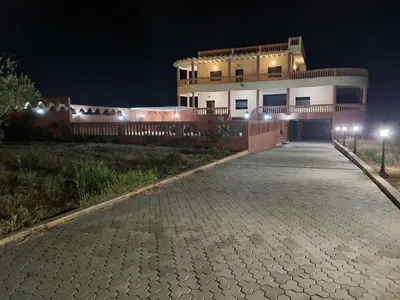a building at night with a cobblestone driveway at Villa des Oliviers MEKNES in Meknès