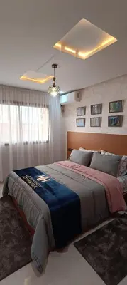 a bedroom with a large bed with a blue blanket at APPART-HOTEL La MAISON ATTAWBA 3 in Beni Mellal