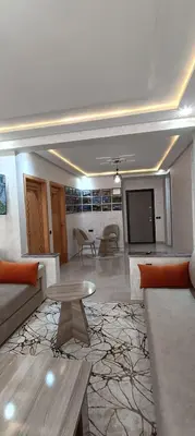 a living room with a couch and a tv at APPART-HOTEL La MAISON ATTAWBA 3 in Beni Mellal