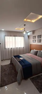 a bedroom with a large bed with a blue blanket at APPART-HOTEL La MAISON ATTAWBA 3 in Beni Mellal