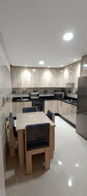 a kitchen with a table and chairs in it at APPART-HOTEL La MAISON ATTAWBA 3 in Beni Mellal