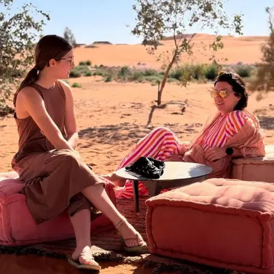 two women sitting on chairs in the desert at Luxurious Desert Camp in Merzouga