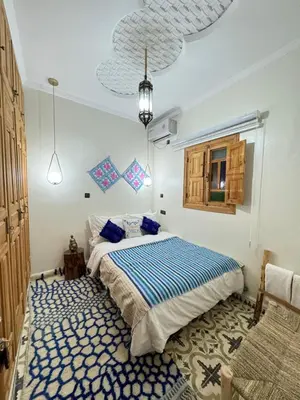 a bedroom with a bed and a blue and white rug at Gite Marbie maison rurale, une expérience naturelle unique, au coeur du moyen atlas, Maroc in Teklit