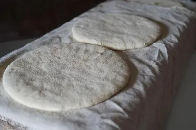 three uncooked pizzas sitting on top of a table at Gite Marbie maison rurale, une expérience naturelle unique, au coeur du moyen atlas, Maroc in Teklit