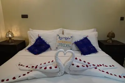 a bed with two swans making a heart on it at Gite Marbie maison rurale, une expérience naturelle unique, au coeur du moyen atlas, Maroc in Teklit