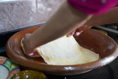 a person is making a dough in a bowl at Gite Marbie maison rurale, une expérience naturelle unique, au coeur du moyen atlas, Maroc in Teklit