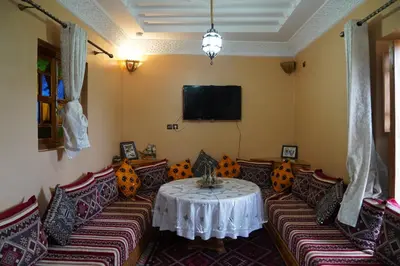 a room with a table and chairs and a tv at Gite Marbie maison rurale, une expérience naturelle unique, au coeur du moyen atlas, Maroc in Teklit