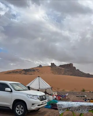 a white suv parked in front of a tent in the desert at Ecolodge Le désert in Kasr Bounou
