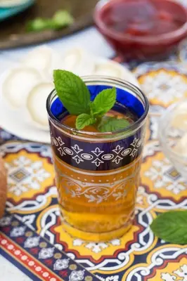 a cup of tea with a green plant in it at Ecolodge Le désert in Kasr Bounou