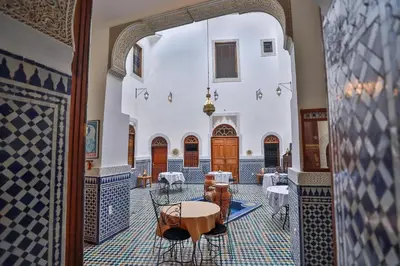 an archway in a building with tables and chairs at Riad Nashira in Fès