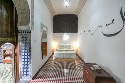 a bedroom with a bed and a table in a room at Riad Nashira in Fès
