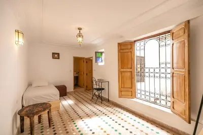 a bedroom with a bed and a window at Riad Nashira in Fès