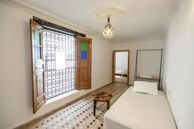 a bedroom with a bed and a window at Riad Nashira in Fès