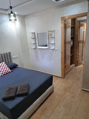 a bedroom with a bed and a mirror on the wall at Nabiloc Apart Hotel - Centre Ville in Fès