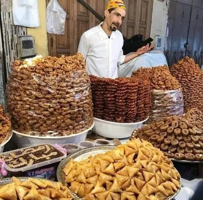 a man standing in front of a table of food at Nabiloc Apart Hotel - Centre Ville in Fès