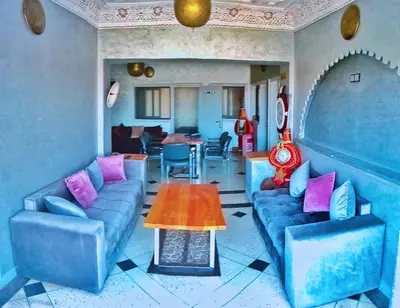 a living room with blue couches and a table at Hotel Restaurant Bougafer in Midelt