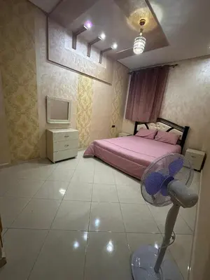 a bedroom with a bed with a fan in it at Appartement fes magnifique in Fès