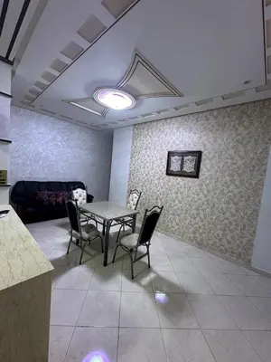 a room with a table and chairs and a couch at Appartement fes magnifique in Fès