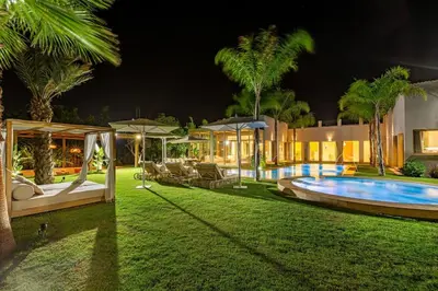 a house with a swimming pool at night at Villa Bahamas , Luxe et élégance & piscine Chauffée, jacuzzi in Marrakech