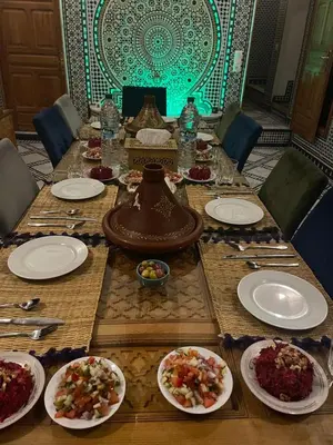 a long table with plates of food on it at RIAD LALJ Fes in Fès