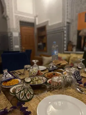 a wooden table with plates of food on it at RIAD LALJ Fes in Fès