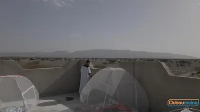 a woman standing on a wall looking out over the desert at Ouboumalne in Tamsahelt