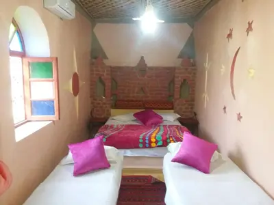 a bedroom with a bed and two couches in it at Chez Belkacem in Merzouga