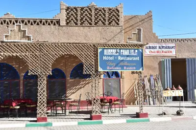 a building with tables and chairs in front of it at Chez Belkacem in Merzouga