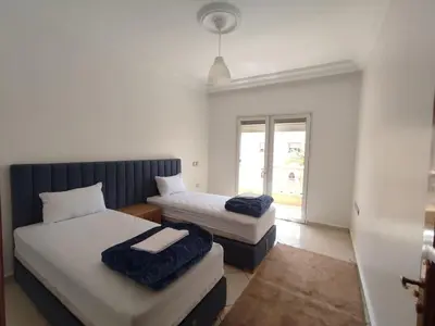 a room with two beds and a window at Appartement Moderne 3 Chambres in Khemisset
