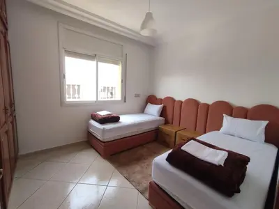 a hotel room with two beds and a window at Appartement Moderne 3 Chambres in Khemisset